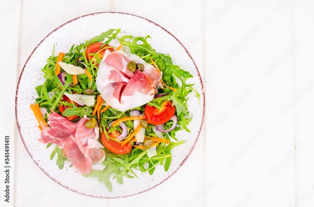 Fresh homemade salad with arugula, jamon, rucola, tomatoes, parmesan. Fresh homemade salad with arugula, jamon, rucola, tomatoes, parmesan.