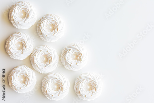 A top down view of several merengue cookies against a white background with copy space to the right.