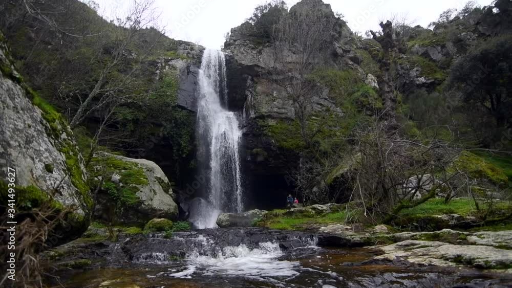 Big waterfall with a little river and a lot of rocks and nature around it Big waterfall with a little river and a lot of rocks and nature around it