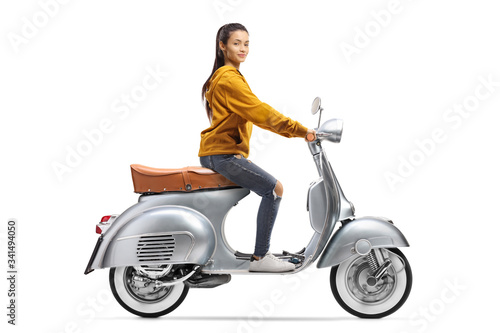 Young casual female riding a silver vintage scooter