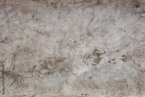 Heavily textured shades of grey stucco or concrete wall with sopts and patterns