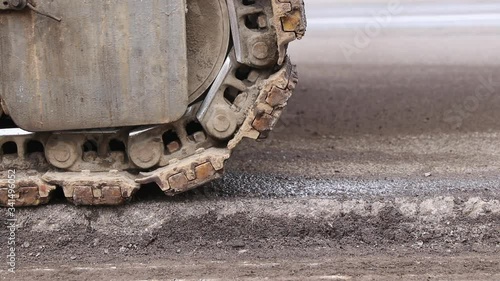 Closeup protector of a metal caterpillar track. Heavy construction bulldozer or tractor moving from left to the right