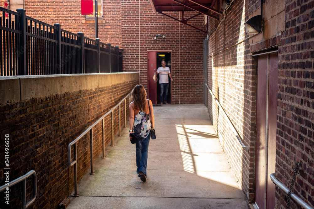 Woman walking towards back entrance of building Woman walking towards back entrance of building
