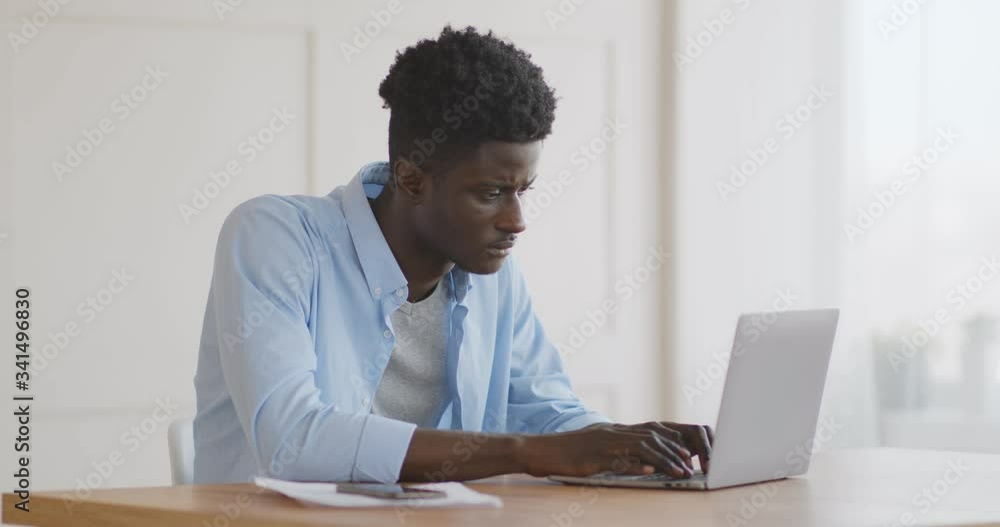 Upset african american man having issues with laptop Upset african american man having issues with laptop