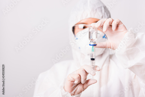 doctor or scientist in PPE suite uniform in lab hold medicine liquid vaccine vial bottle and syringe