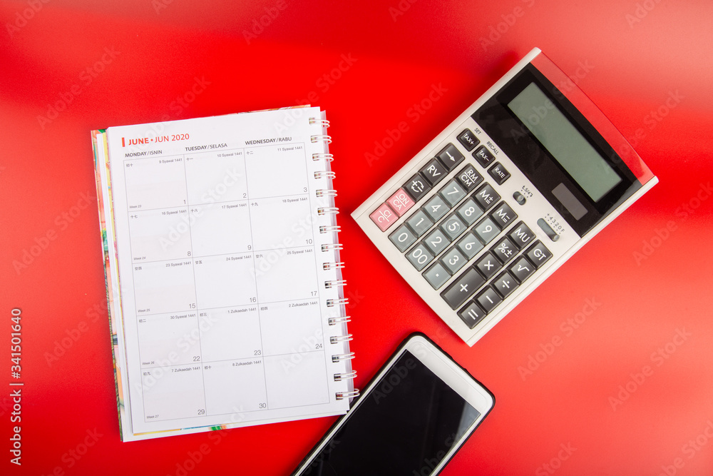 Calculator with daily book calendar, Smartphone and Tax Words-Financial Concept Calculator with daily book calendar, Smartphone and Tax Words-Financial Concept