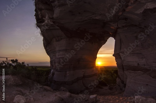 Sunset view through the rock, colorful arenite, contrasting with green vegetations and blue sky in Pedra furada tourist attraction, Jalapao, Brazil. photo