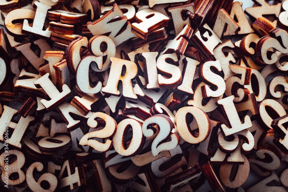 Stack of macro wooden letterpress letters with the text economic crisis in 2020. Stack of macro wooden letterpress letters with the text economic crisis in 2020.