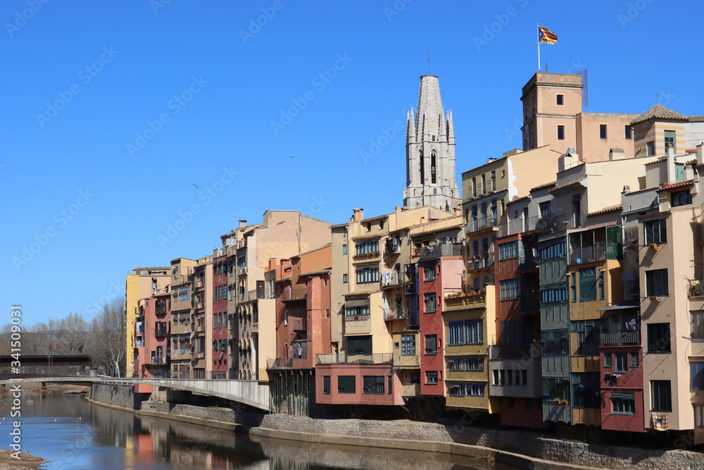 Colored houses on the Onyar River in the background of the Church of St. Felix, in Girona, Catalonia, Spain