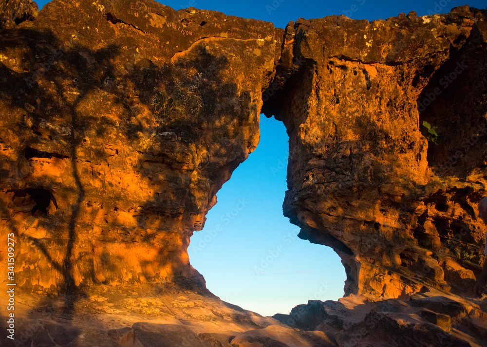 Sunset view trhouogh the rock hole (Pedra furada), in Portal da chapada, a trourist attraction in Chapada das mesas, Brazil