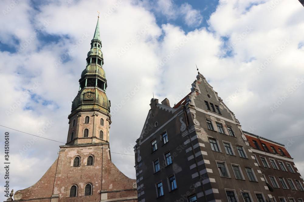 View of the tower of St. Peter's Church in Riga and the old house, Latvia