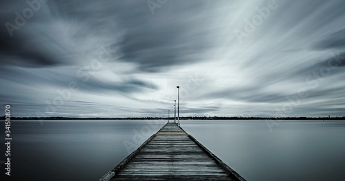 Wooden jetty long exposure with swirling clouds