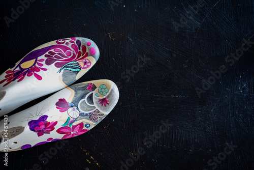 Vintage hand painted wooden shoe mold on a black rustic background © Maximiliano Ramos