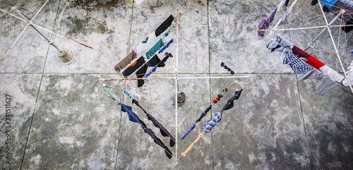overhead view of a rotary washing line drying laundry in a concrete courtyard. photo