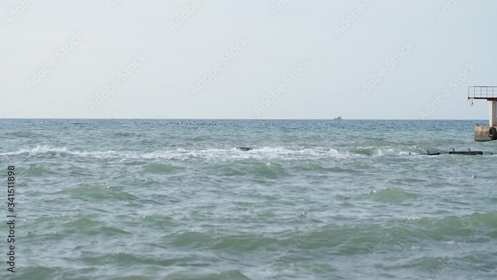 Seascape in good weather. View on old rusty pier from beach. Sochi, Russia. Seascape in good weather. View on old rusty pier from beach. Sochi, Russia.