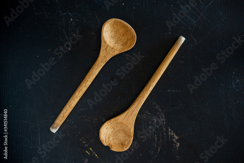 Vista superior de dos cucharas de cocina de madera en una mesa de cocina de madera negra
