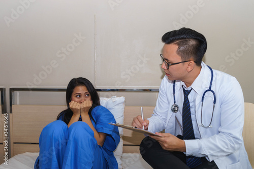 Middle aged Asian psychiatrist and his female patient.