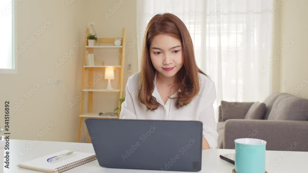 Young adult Asian woman work at home or modern office, using notebook laptop computer. Work from home life, information technology, domestic lifestyle, or self isolation remote working concept Young adult Asian woman work at home or modern office, using notebook laptop computer. Work from home life, information technology, domestic lifestyle, or self isolation remote working concept