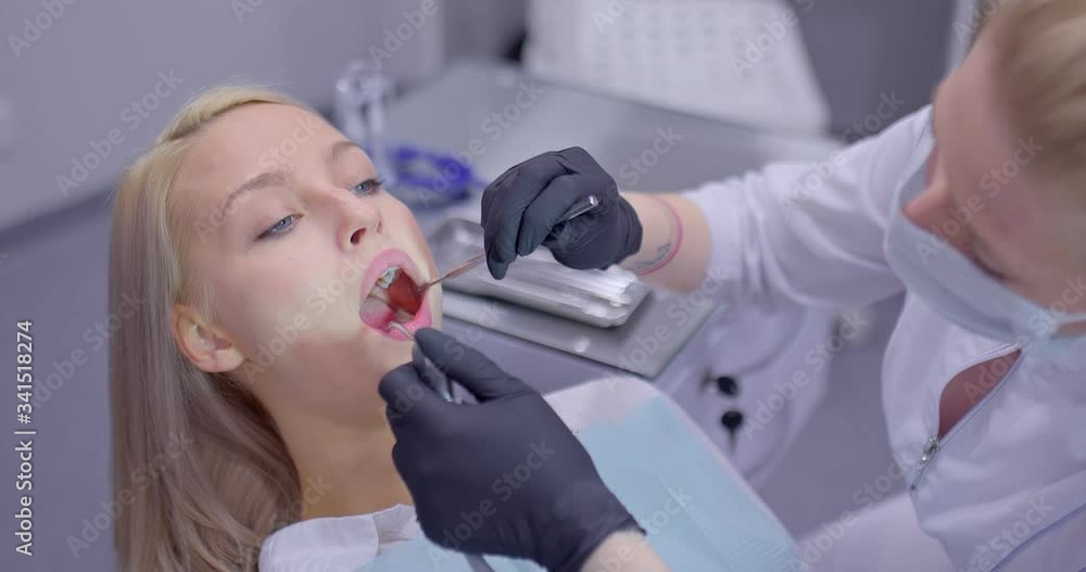 Caries treatment in modern dentistry. Dentist takes a drill and begins