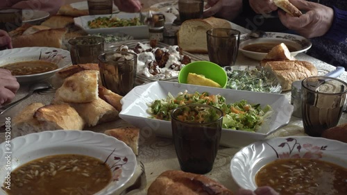 Crowded Turkish muslim family having a dinner together around a table eating food