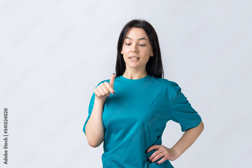 Happy young caucasian female in a blue t-shirt pointing fingers away Happy young caucasian female in a blue t-shirt pointing fingers away