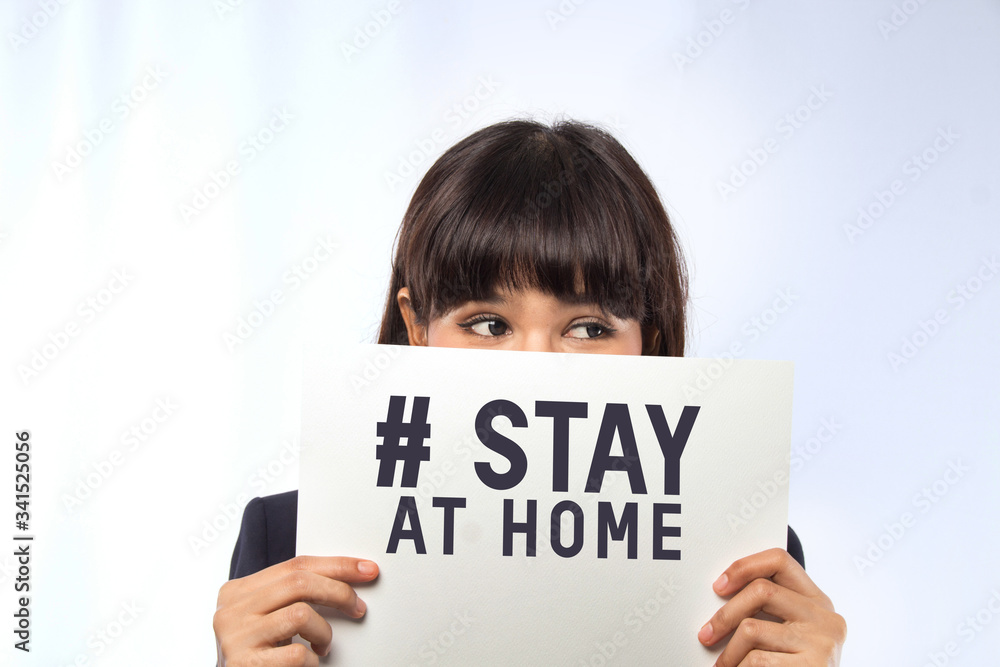 Businesswoman holding card with stay at home text. Businesswoman holding card with stay at home text.