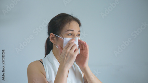 Asian woman in medical mask stay isolation at home for self quarantine.