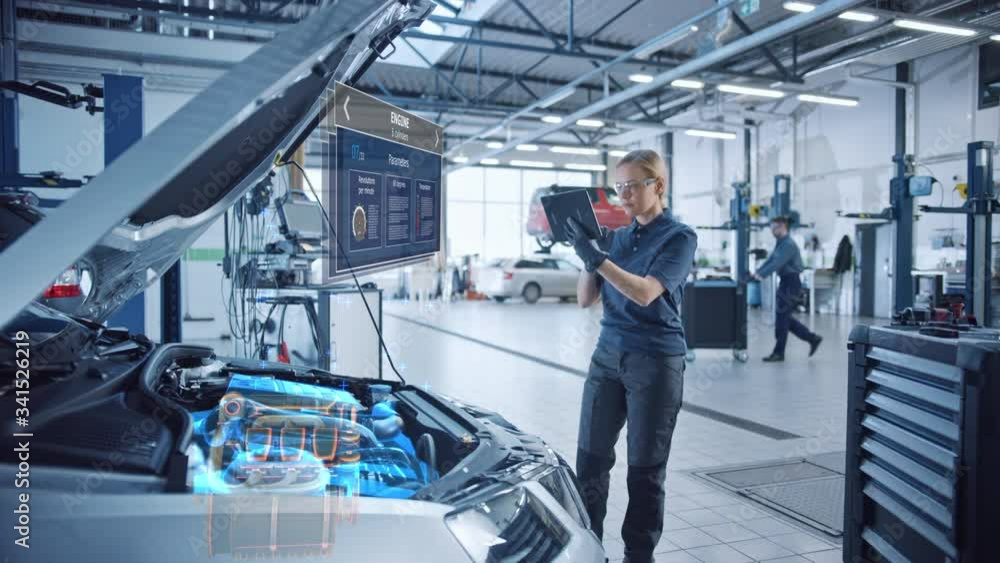 Female Mechanic Uses a Tablet Computer with an Augmented Reality Diagnostics Software. Specialist Inspecting Car's V6 Engine in Order to Find Broken Components. Hi-tech Modern Car Service. Female Mechanic Uses a Tablet Computer with an Augmented Reality Diagnostics Software. Specialist Inspecting Car's V6 Engine in Order to Find Broken Components. Hi-tech Modern Car Service.