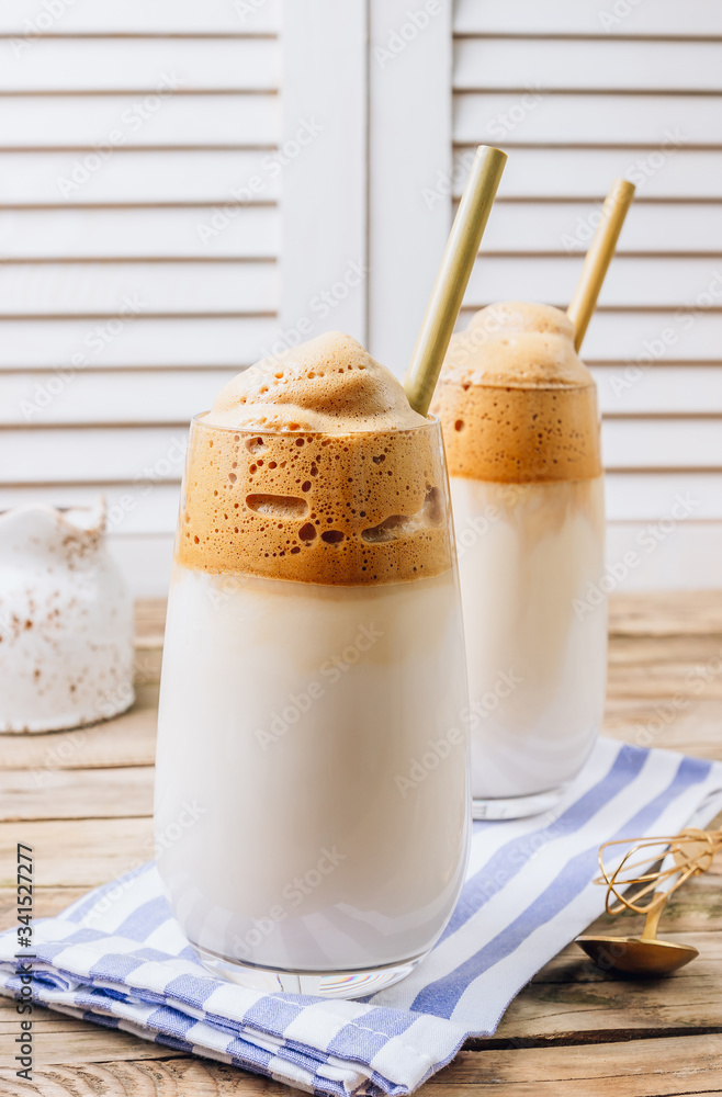 Iced frothy Dalgona Coffee, a trendy fluffy creamy whipped coffee. Korean drink latte espresso with coffee foam. made of instant coffee, sugar, hot water and milk. Iced frothy Dalgona Coffee, a trendy fluffy creamy whipped coffee. Korean drink latte espresso with coffee foam. made of instant coffee, sugar, hot water and milk.