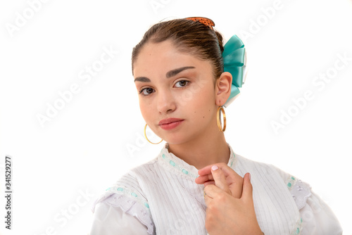 Bailarina latina adolescente, bailando polka mexicana de Nuevo León, México, con fondo blanco y falda verde, con botas negras y sonriente, moda mexicana, folklor de mexico, traje tipico mexicano photo