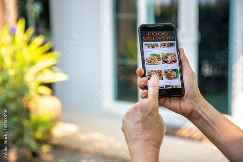 The woman uses the application on the mobile to order food delivery.