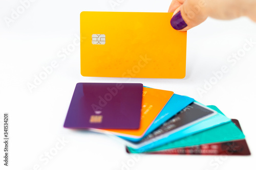 Woman holding orange credit card over multiple credit cards