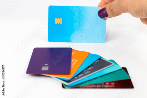 Woman holding blue credit card over multiple credit cards