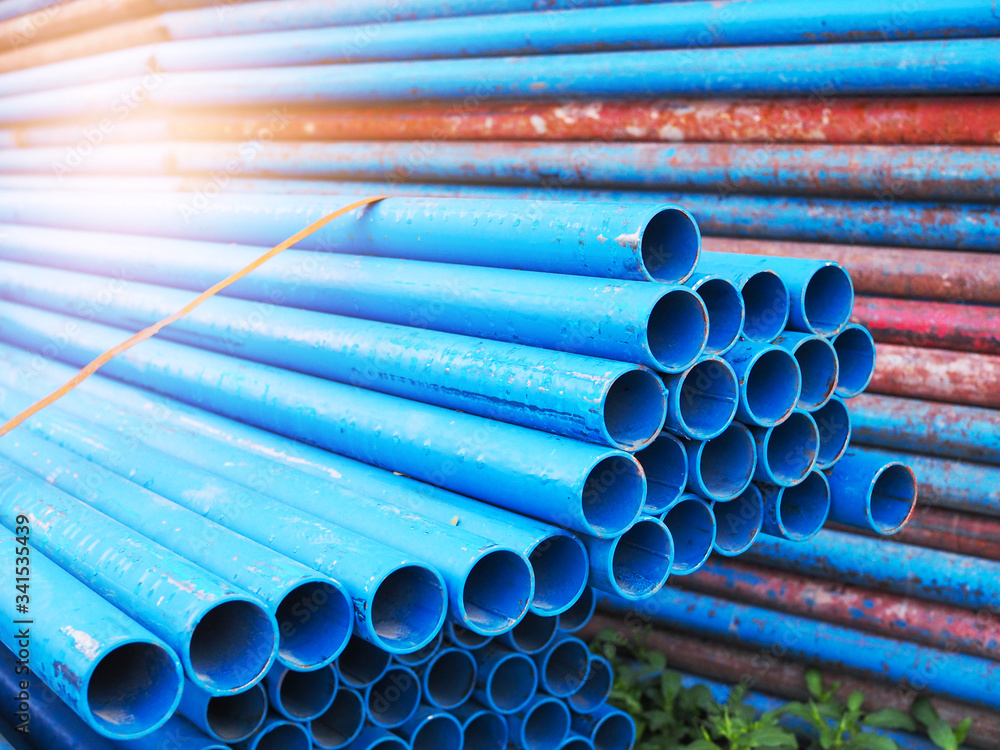 Blue steel pipe pile stacked on construction site. - obrazy, fototapety, plakaty 
