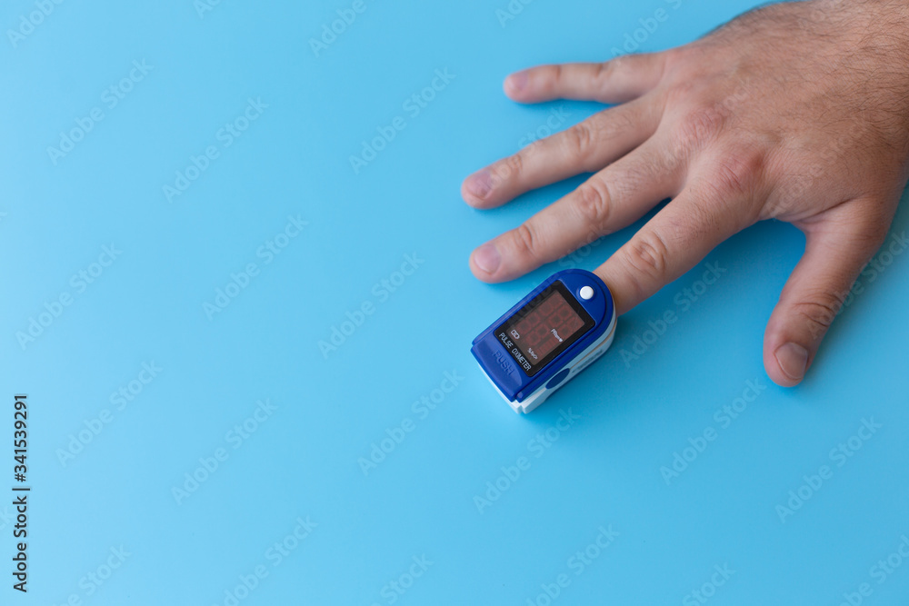 Pulse Oximeter On a male finger. Man using Oximeter. Healthy Concept Pulse Oximeter On a male finger. Man using Oximeter. Healthy Concept