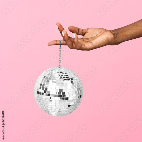 Shiny disco ball handing in a finger