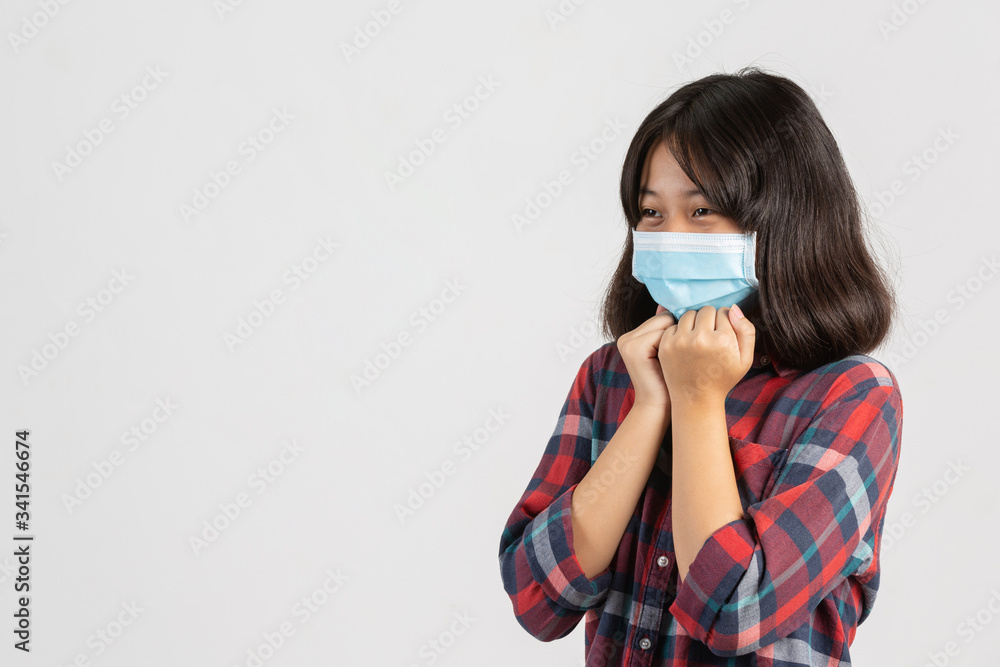 Cute girl is wearing mask while soaring throat on white background.