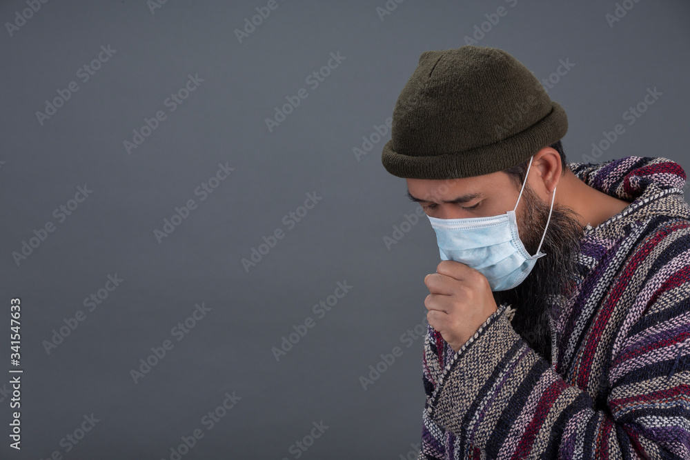 Old man is wearing mask while coughing on gray background. Old man is wearing mask while coughing on gray background.