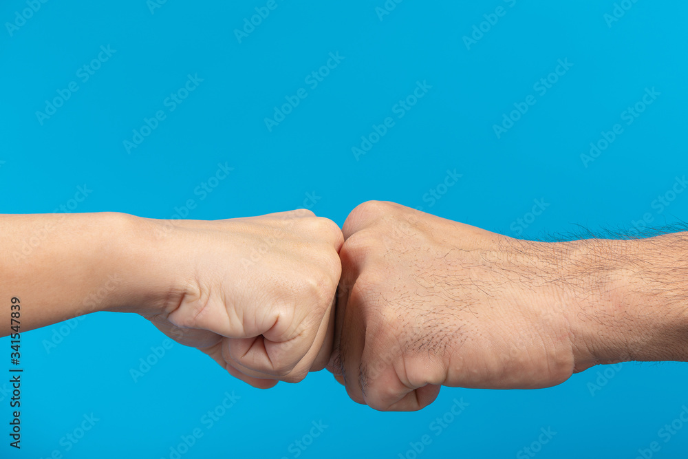 Hand punch between young boy and young girl on blue background. Hand punch between young boy and young girl on blue background.