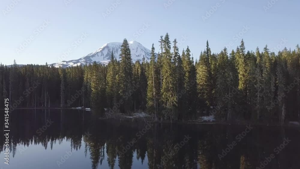 Volcano Mount Adams at Sunrise with Smooth Lake Reflection. Washington State, Great Northwest, United States of America. Mountain lake with turquoise water and green trees. Beautiful spring landscape Volcano Mount Adams at Sunrise with Smooth Lake Reflection. Washington State, Great Northwest, United States of America. Mountain lake with turquoise water and green trees. Beautiful spring landscape