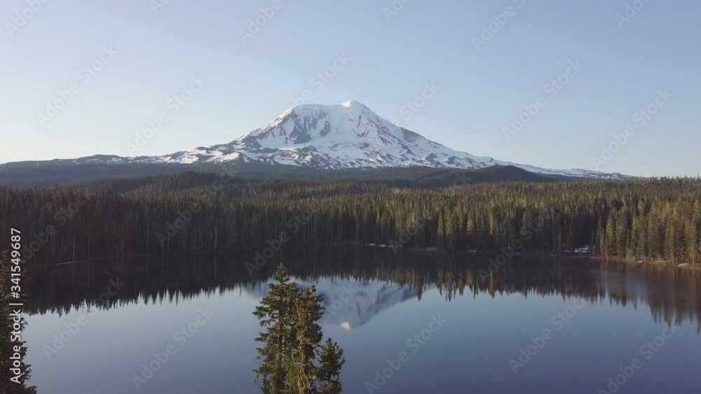 Volcano Mount Adams at Sunrise with Smooth Lake Reflection. Washington State, Great Northwest, United States of America. Mountain lake with turquoise water and green trees. Beautiful spring landscape Volcano Mount Adams at Sunrise with Smooth Lake Reflection. Washington State, Great Northwest, United States of America. Mountain lake with turquoise water and green trees. Beautiful spring landscape