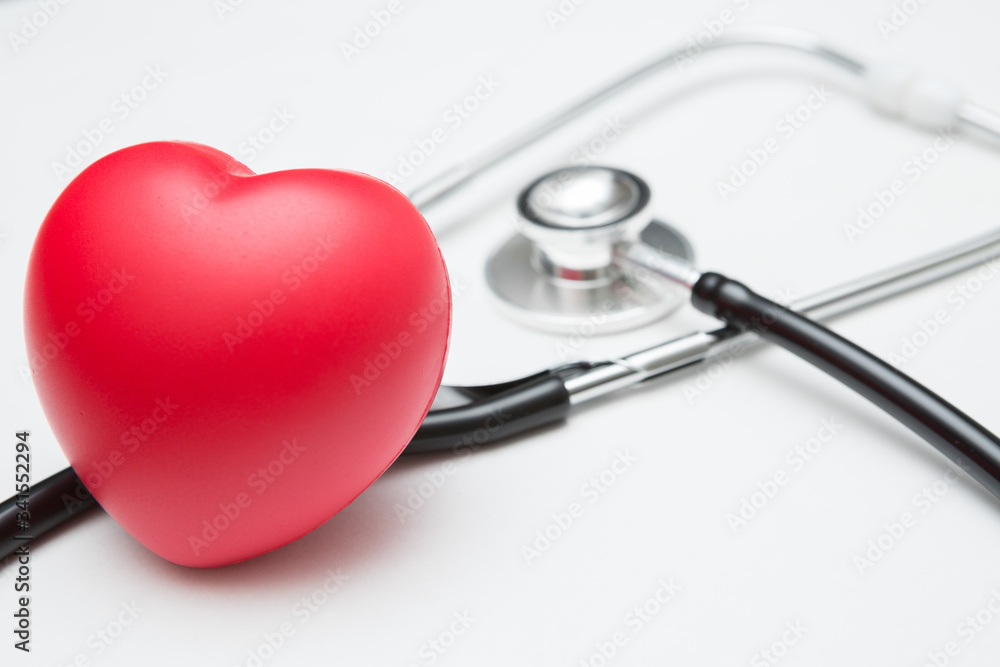 Heart shaped squeeze ball for hand muscle exercise and stethoscope on white background and copy space Heart shaped squeeze ball for hand muscle exercise and stethoscope on white background and copy space
