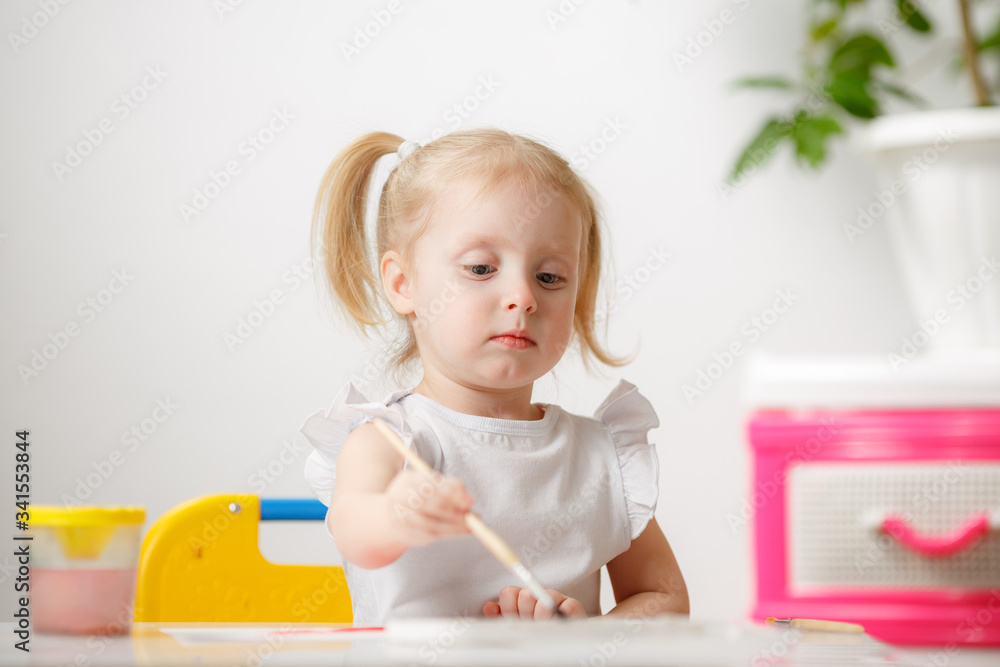 Little Girl Draws Watercolors While At Home In Her Room. The Child is Engaged In Creativity. Little Artist. Little Girl Draws Watercolors While At Home In Her Room. The Child is Engaged In Creativity. Little Artist.