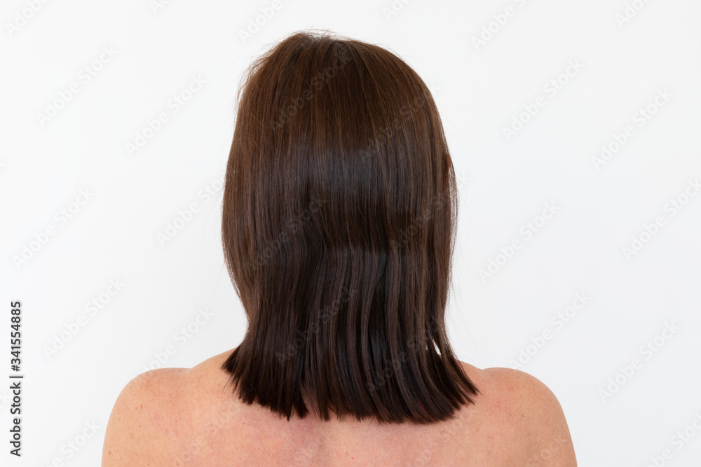 Nude woman facing a white wall