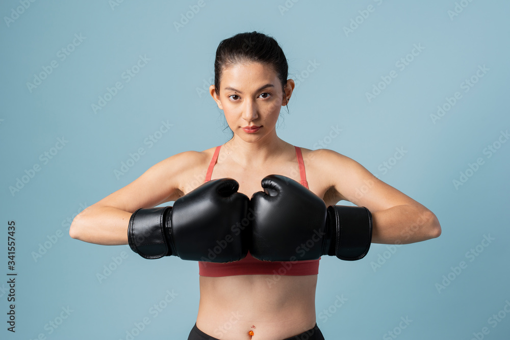 Sportive woman ready to fight on blue background Sportive woman ready to fight on blue background