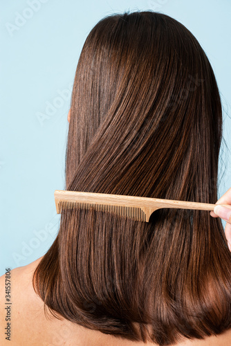 Stylist combing a woman's hair photo