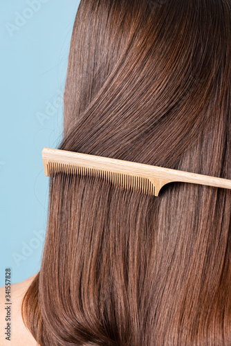 Vászonkép Woman combing her sleek hair
