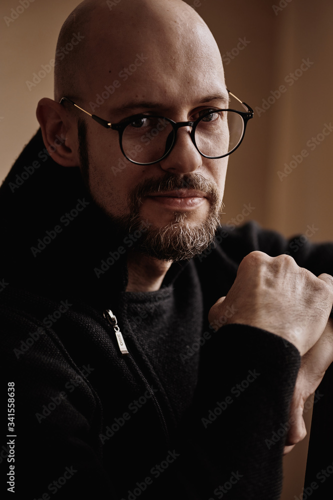 Fototapeta premium Bald brutal man in glasses with a beard, black and white portrait.