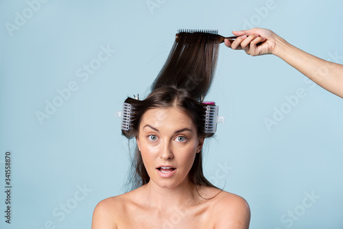 Young woman using hair curlers