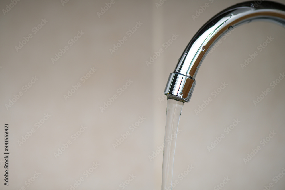 Water flowing from the faucet to the washbasin Water flowing from the faucet to the washbasin